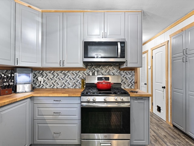 kitchen featuring appliances with stainless steel finishes, butcher block countertops, and dark wood finished floors