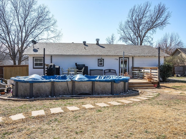 back of property featuring a fenced in pool, fence, and a deck