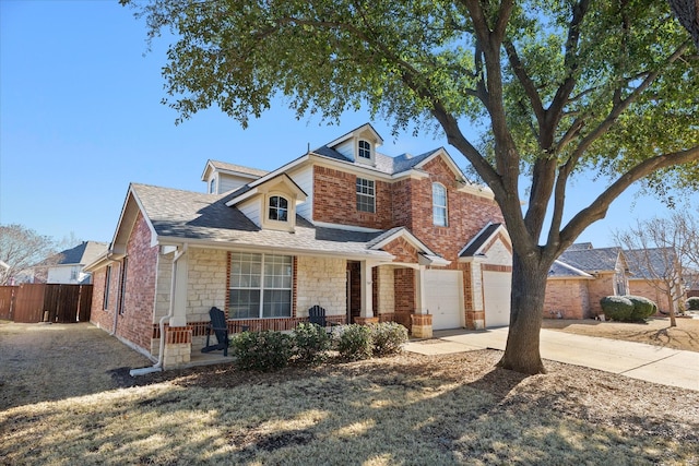 view of front facade with brick siding, fence, concrete driveway, stone siding, and roof with shingles