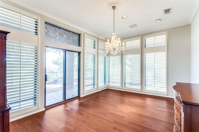 interior space featuring visible vents, a chandelier, crown molding, and wood finished floors