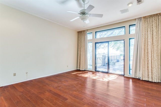 unfurnished room featuring ceiling fan, wood finished floors, visible vents, baseboards, and ornamental molding