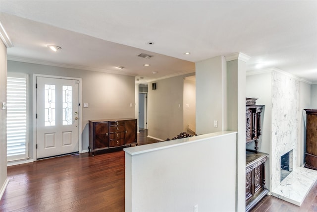 kitchen featuring dark wood-type flooring, a wealth of natural light, a fireplace, and crown molding