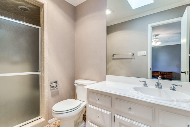 ensuite bathroom with a ceiling fan, toilet, crown molding, vanity, and a shower stall