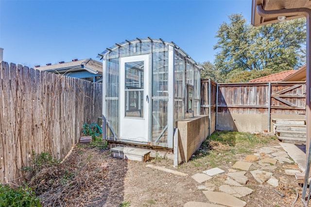 view of greenhouse with a fenced backyard