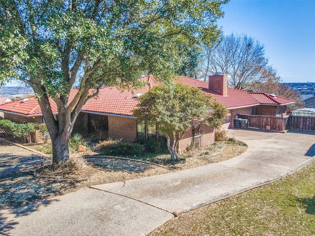 view of front of property with a chimney and a tile roof