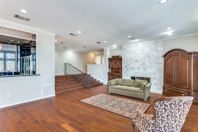 living room with a high end fireplace, wood finished floors, visible vents, and stairs