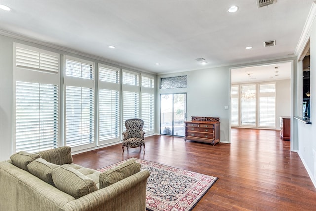 living area featuring baseboards, visible vents, ornamental molding, dark wood-type flooring, and recessed lighting