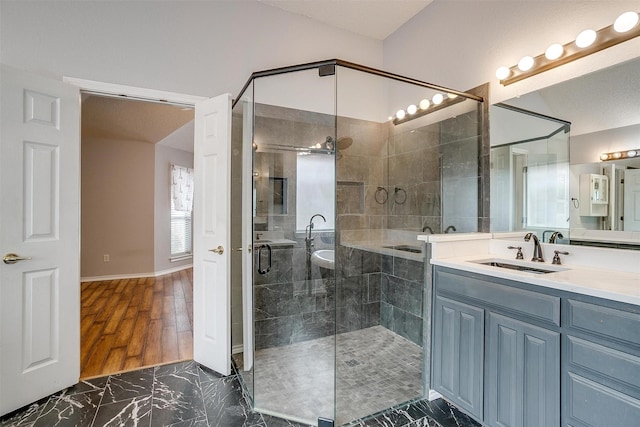 full bathroom featuring marble finish floor, a stall shower, and vanity