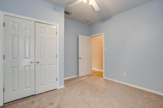 unfurnished bedroom with visible vents, a textured ceiling, a closet, carpet floors, and baseboards