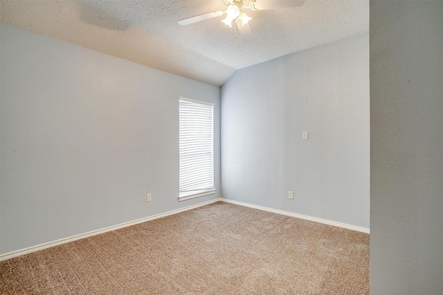 carpeted empty room featuring baseboards, a textured ceiling, lofted ceiling, and a ceiling fan