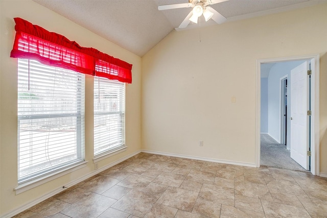 empty room with baseboards, a textured ceiling, a ceiling fan, and vaulted ceiling