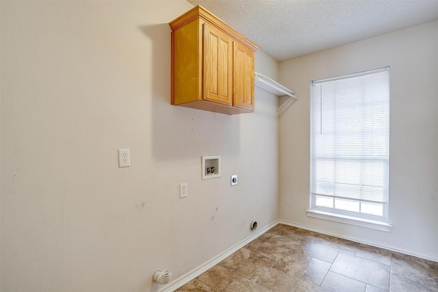 laundry area with electric dryer hookup, a textured ceiling, cabinet space, baseboards, and hookup for a washing machine