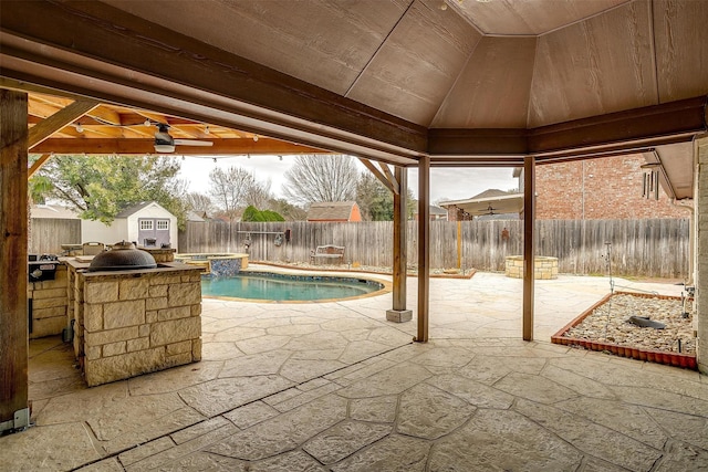 view of swimming pool featuring a fenced backyard, a fenced in pool, a storage unit, and a patio