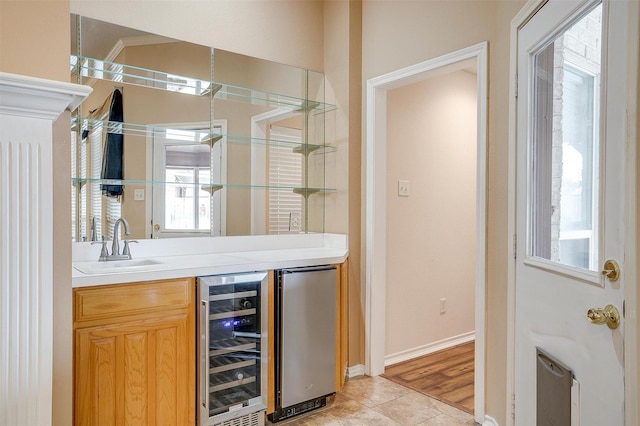 bar featuring beverage cooler, baseboards, light tile patterned flooring, a sink, and fridge