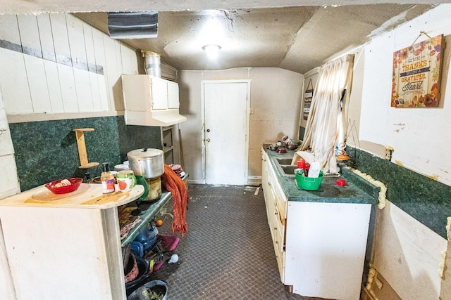 kitchen with lofted ceiling and white cabinetry