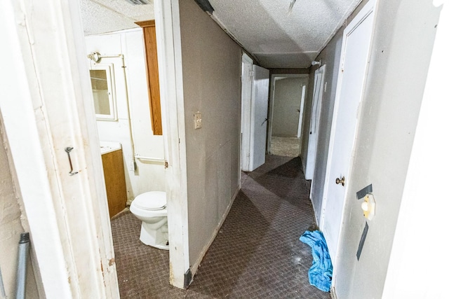 hall featuring a textured ceiling