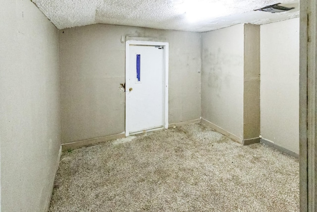 carpeted spare room featuring baseboards and a textured ceiling