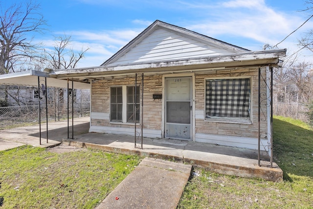 view of front facade with a porch, a front yard, and fence