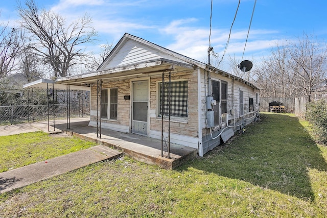 shotgun-style home featuring a patio, a front yard, and fence