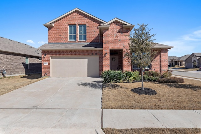 traditional home featuring concrete driveway, an attached garage, and brick siding