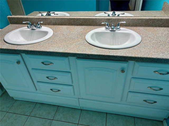 bathroom featuring tile patterned floors, a sink, and double vanity