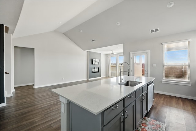 kitchen with a sink, dark wood-style floors, open floor plan, lofted ceiling, and dishwasher