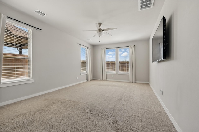 unfurnished room with visible vents, baseboards, and light colored carpet