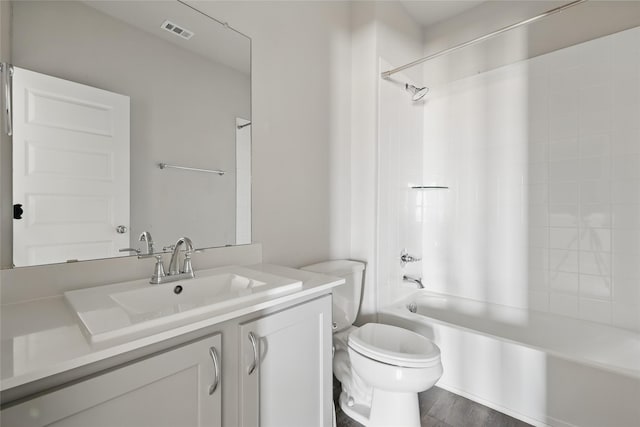 bathroom featuring visible vents, toilet, wood finished floors, shower / bath combination, and vanity