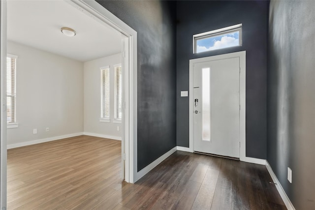 foyer entrance with baseboards and wood finished floors