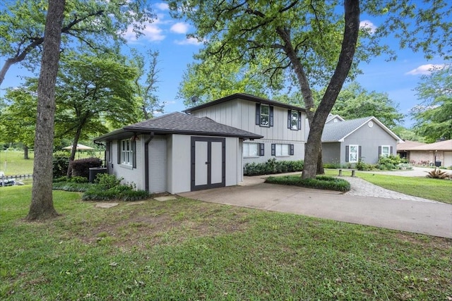 view of front of home featuring driveway, roof with shingles, a front lawn, and brick siding