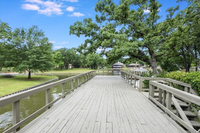 wooden deck featuring a water view and a yard