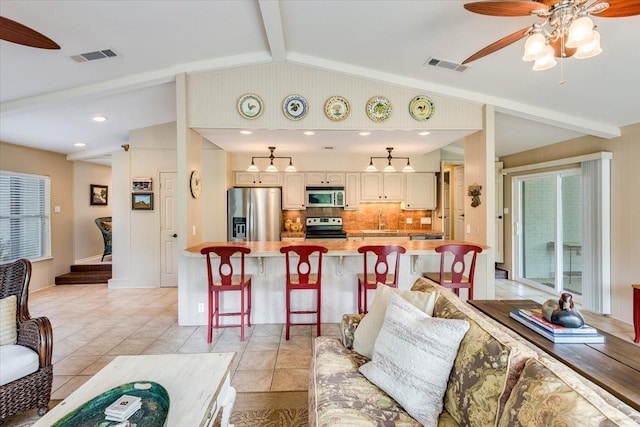 living area featuring lofted ceiling with beams, recessed lighting, visible vents, and a ceiling fan