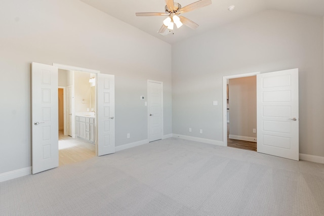 unfurnished bedroom with light carpet, baseboards, high vaulted ceiling, and ceiling fan