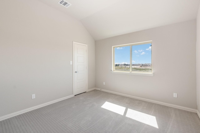 spare room with lofted ceiling, visible vents, light carpet, and baseboards