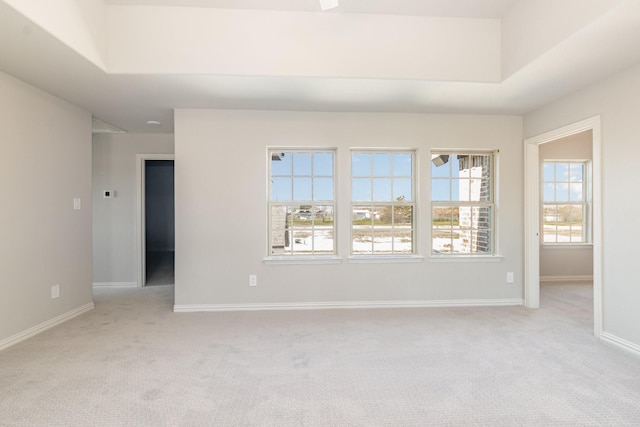 empty room featuring light carpet and baseboards