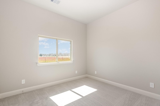 empty room with light colored carpet, visible vents, and baseboards