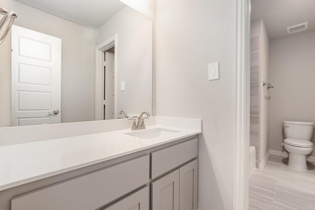 bathroom with baseboards, visible vents, toilet, a bathtub, and vanity