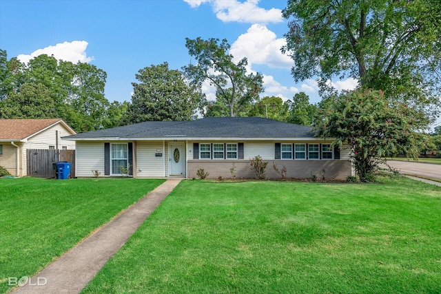 ranch-style house with fence, a front lawn, and brick siding