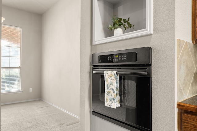 kitchen with baseboards, carpet flooring, and dobule oven black