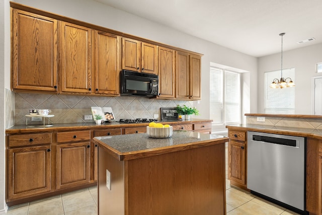 kitchen with black appliances, tasteful backsplash, brown cabinetry, and a kitchen island