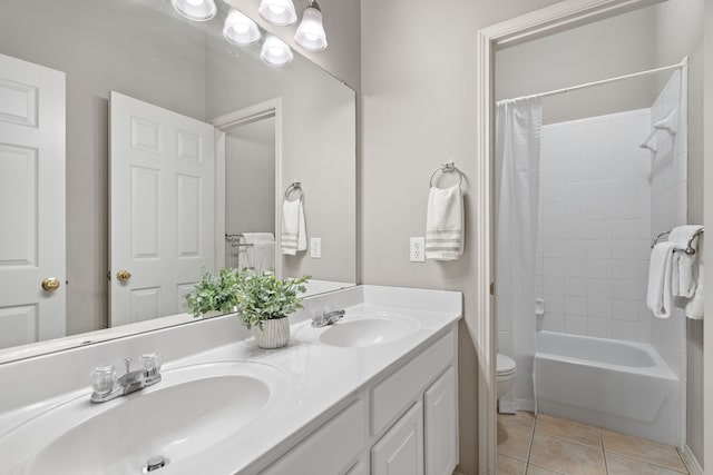 bathroom with shower / tub combo with curtain, tile patterned flooring, a sink, and toilet