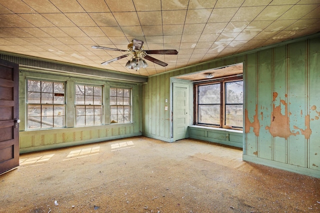 unfurnished room featuring a ceiling fan and baseboards