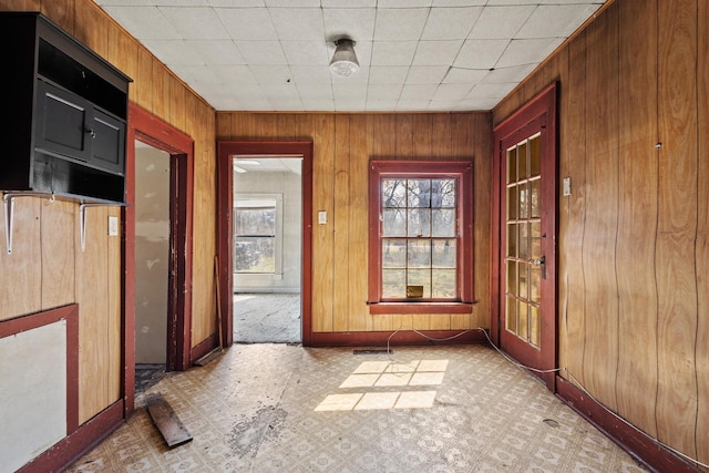 interior space featuring wood walls, baseboards, and light floors