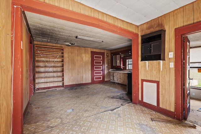 spare room featuring wooden walls and tile patterned floors