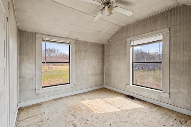 spare room with lofted ceiling, a wealth of natural light, and a ceiling fan