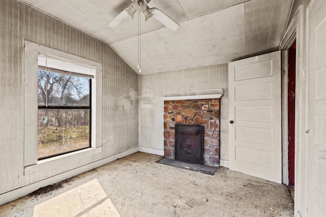 unfurnished living room with lofted ceiling, ceiling fan, and a fireplace