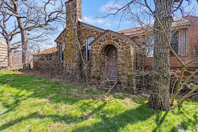 view of front of property with stone siding and a chimney