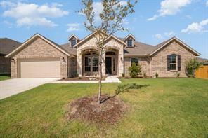 view of front of property featuring an attached garage, concrete driveway, and a front yard