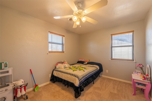 carpeted bedroom with ceiling fan and baseboards