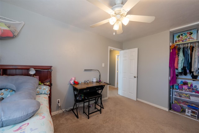 carpeted bedroom with ceiling fan, a closet, and baseboards